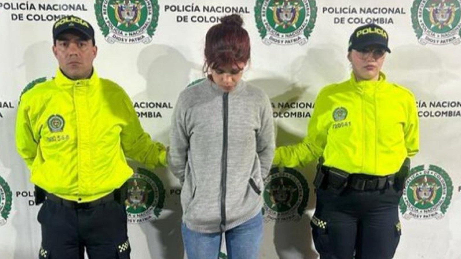 En foto: Katerine Martínez tras ser capturada, con la babeza agachada con un policía a cada lado