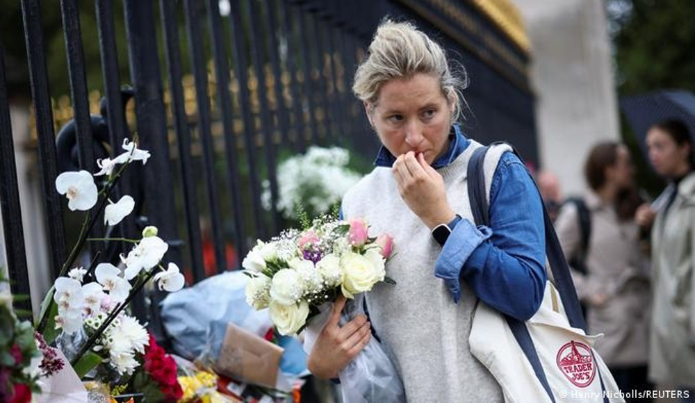 Una mujer lleva flores a Buckingham Palace.